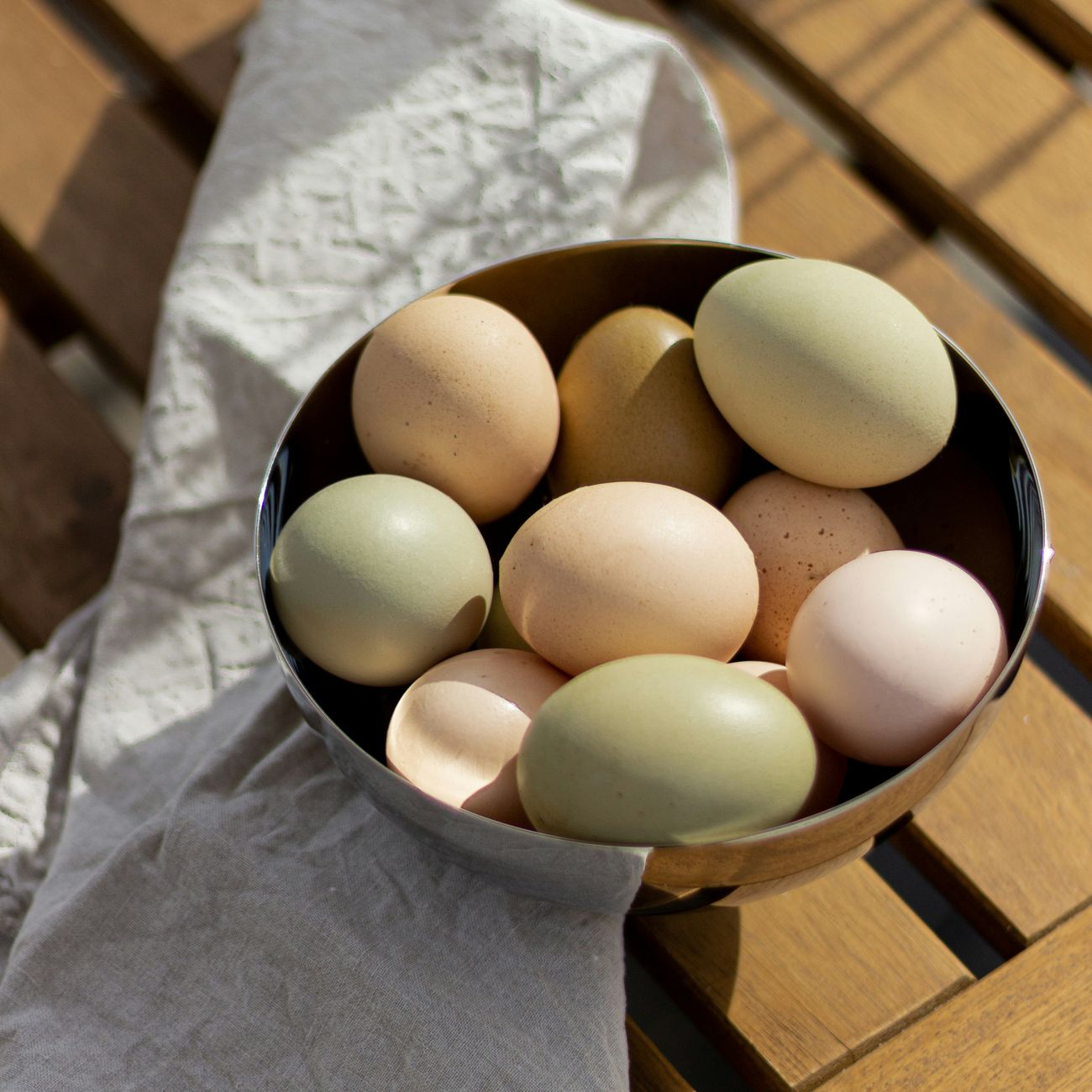 A bowl of fresh eggs in shades of brown, cream and green